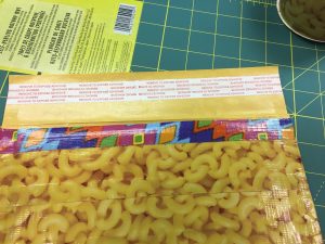 Image of a padded mailer being covered in more duct tape.