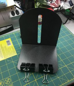 Image of a bookend with binder clips attached at the bottom