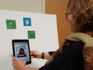 Image of Kathryn using the HP Reveal app to augment the icon for "finished".